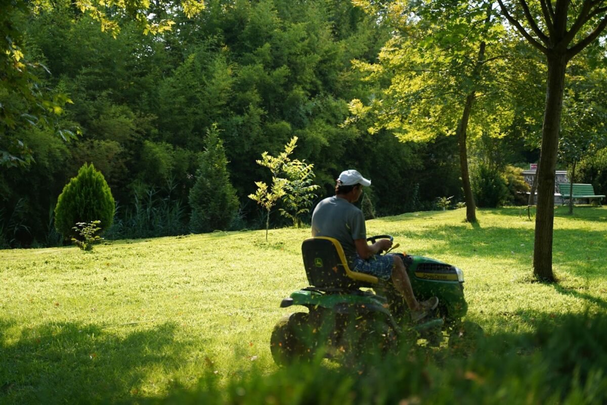 un jardinier qui tond une pelouse