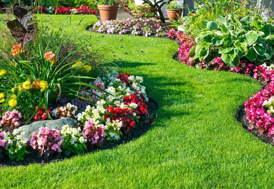 Jardin paysager avec pelouse verte soignée et massifs fleuris