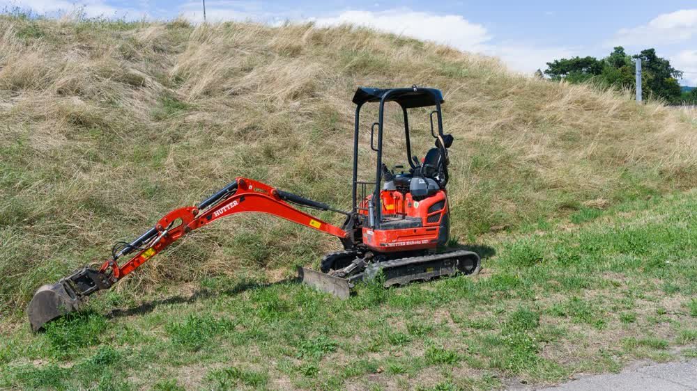 Mini-pelle utilisée pour le dessouchage complet d'une souche